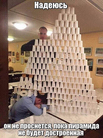 Серьёзный мужик строит пирамиду из стаканчиков!