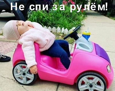 Девочка спит за рулём игрушечной машины
